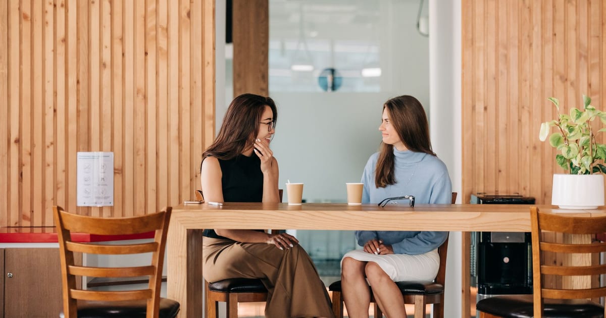 Two people having a supportive conversation over coffee